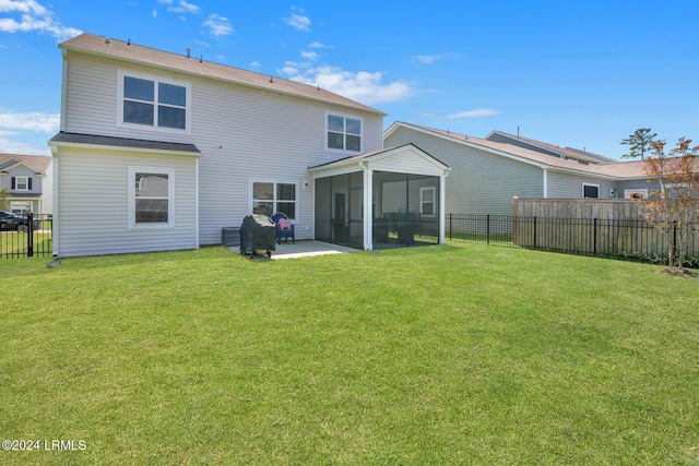 back of house featuring a sunroom and a lawn