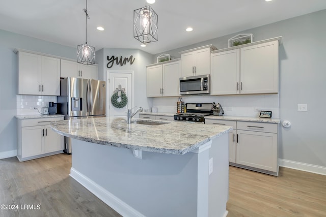 kitchen with a kitchen island with sink, sink, white cabinets, and appliances with stainless steel finishes