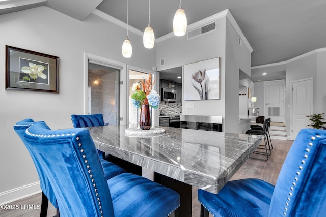 dining space with hardwood / wood-style flooring and ornamental molding