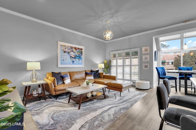 living room featuring hardwood / wood-style flooring, crown molding, and a notable chandelier