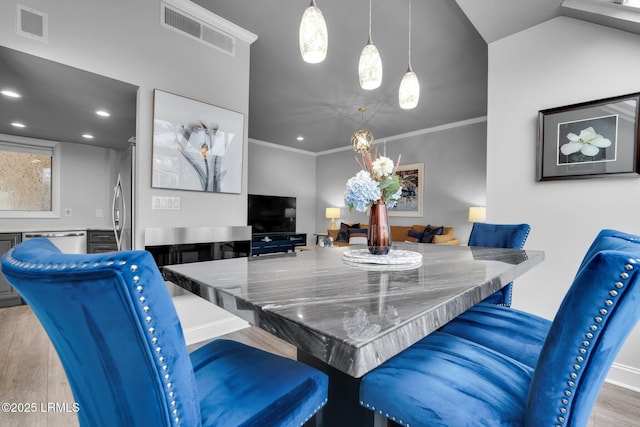 dining room featuring crown molding and light hardwood / wood-style flooring