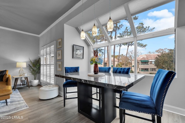 dining space featuring wood-type flooring, plenty of natural light, and ornamental molding