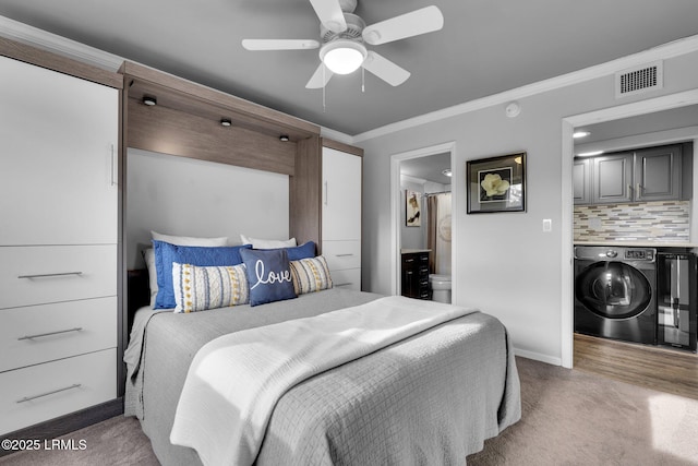 bedroom with crown molding, connected bathroom, washer / dryer, and carpet flooring