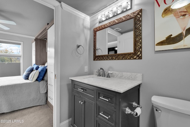 bathroom featuring vanity, ceiling fan, ornamental molding, and toilet