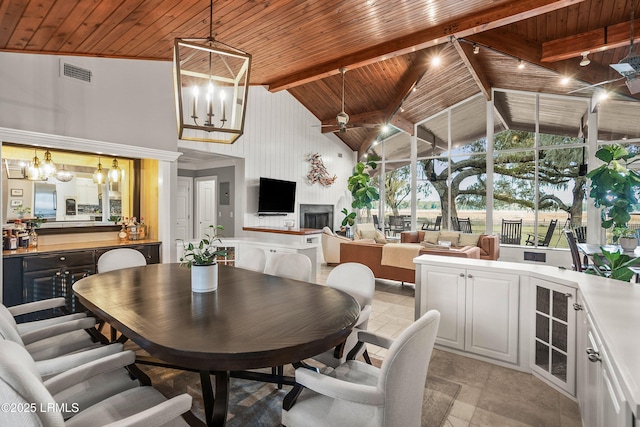 dining space featuring visible vents, wooden ceiling, beam ceiling, high vaulted ceiling, and track lighting