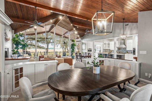 dining space with ceiling fan with notable chandelier, high vaulted ceiling, wooden ceiling, and visible vents