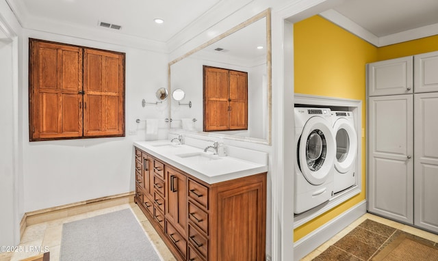 laundry room featuring crown molding, visible vents, a sink, and washing machine and clothes dryer