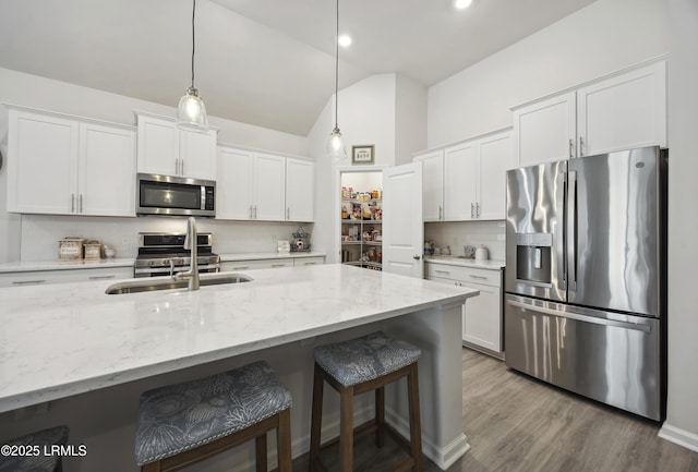 120 Sifted Grain Rd, Bluffton, SC 29909 - kitchen featuring appliances with stainless steel finishes, a sink, tasteful backsplash, a kitchen breakfast bar, and white cabinetry