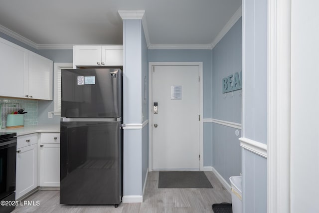 663 William Hilton Pkwy Unit 2126, Hilton Head Island, SC 29928 - kitchen featuring freestanding refrigerator, light countertops, white cabinets, light wood-type flooring, and ornamental molding