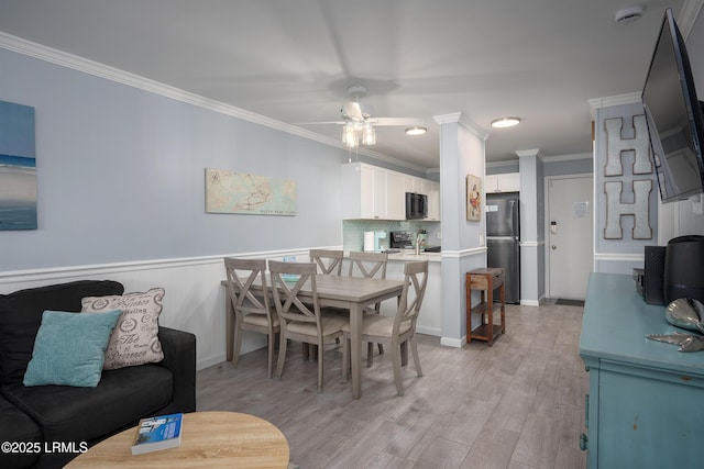 663 William Hilton Pkwy Unit 2126, Hilton Head Island, SC 29928 - dining area featuring ceiling fan, crown molding, light wood-style flooring, and wainscoting
