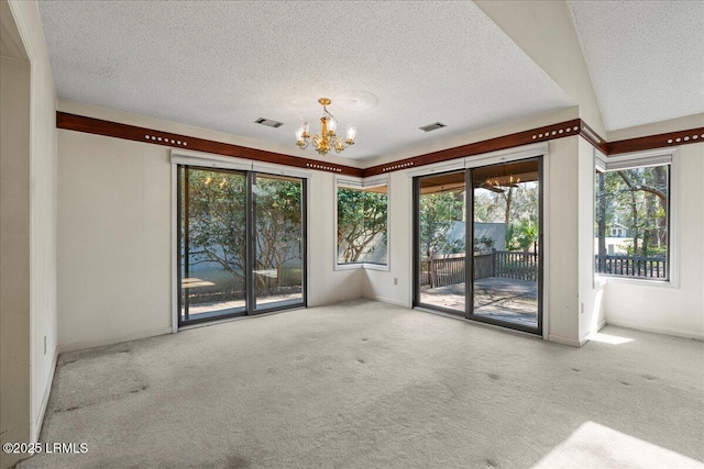 unfurnished room featuring a chandelier, carpet, and visible vents