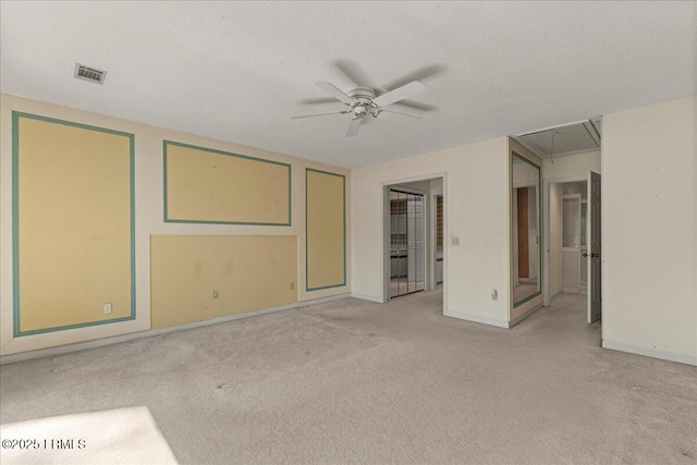 unfurnished bedroom featuring a textured ceiling, carpet flooring, visible vents, baseboards, and attic access