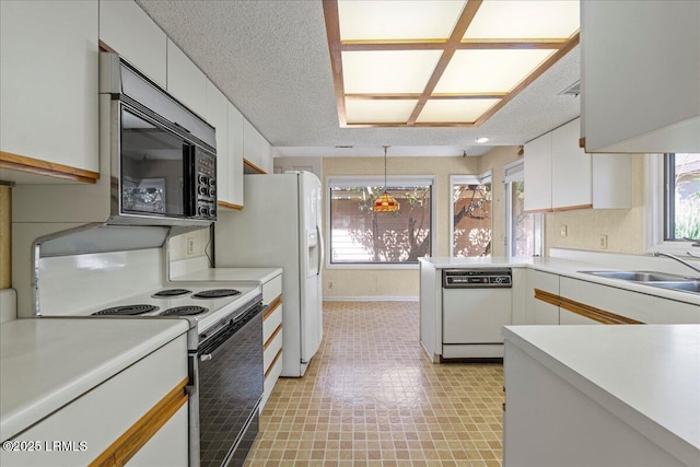 kitchen featuring range with electric cooktop, black microwave, light countertops, and dishwasher