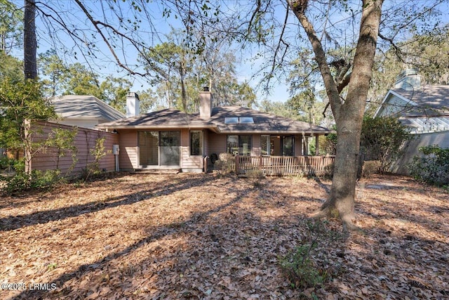 back of property with fence and a chimney