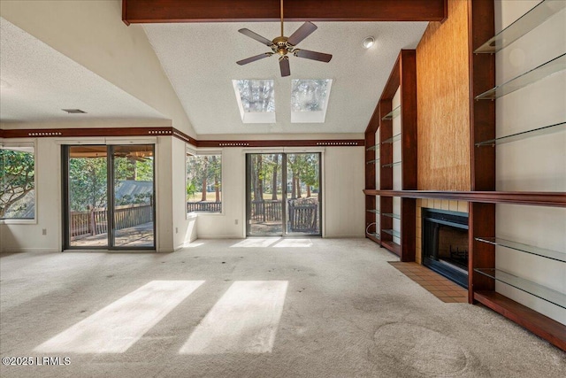 unfurnished living room featuring carpet floors, a textured ceiling, a fireplace, and beamed ceiling