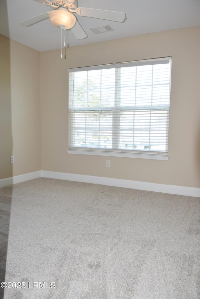 spare room featuring ceiling fan and carpet