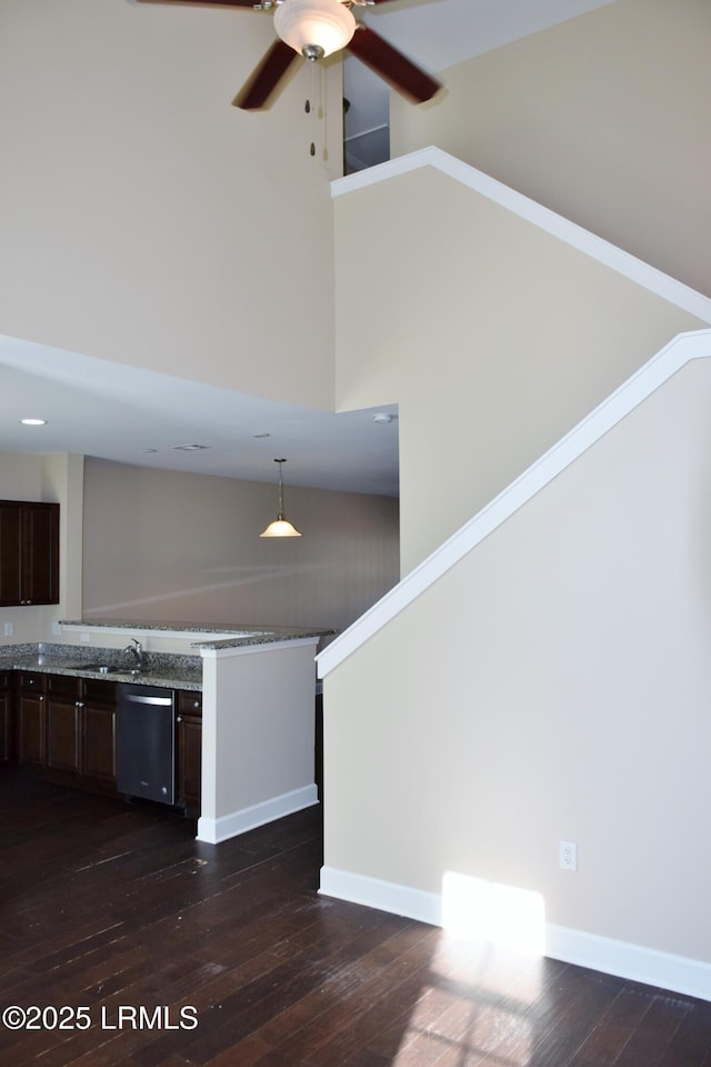 interior space with pendant lighting, dark brown cabinetry, dark hardwood / wood-style flooring, and dishwasher