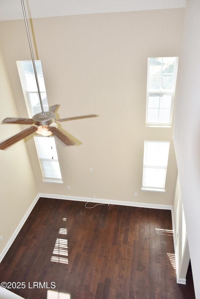 spare room featuring hardwood / wood-style flooring, ceiling fan, and a skylight