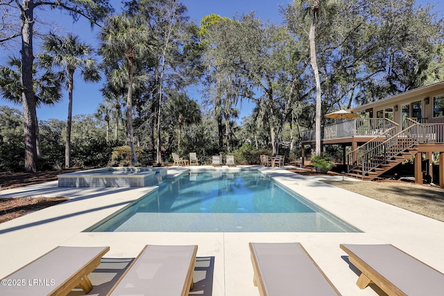 pool featuring a deck, stairway, and a patio area