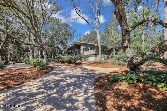 34 W Beach Lagoon Dr, Hilton Head Island, SC 29928 - view of front facade featuring driveway, a sunroom, and stucco siding