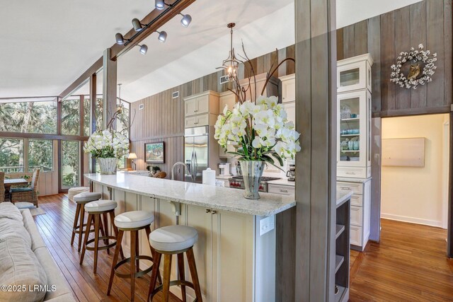 34 W Beach Lagoon Dr, Hilton Head Island, SC 29928 - kitchen featuring a kitchen bar, built in refrigerator, dark wood-type flooring, and light stone countertops