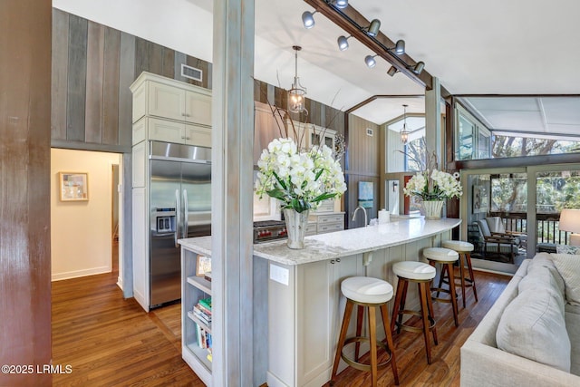 34 W Beach Lagoon Dr, Hilton Head Island, SC 29928 - kitchen with stainless steel built in refrigerator, open floor plan, a breakfast bar area, and wood finished floors