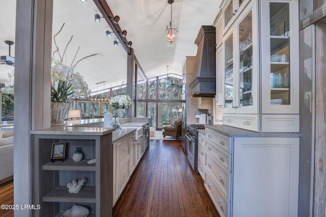 34 W Beach Lagoon Dr, Hilton Head Island, SC 29928 - kitchen featuring high end range, dark wood-style flooring, a sink, glass insert cabinets, and wall chimney exhaust hood