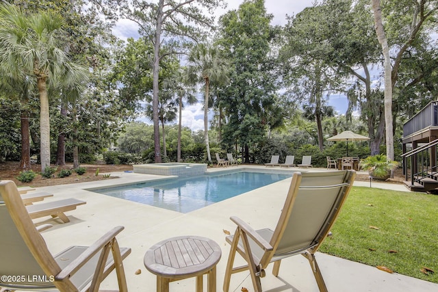 view of swimming pool with a patio, a yard, and a pool with connected hot tub