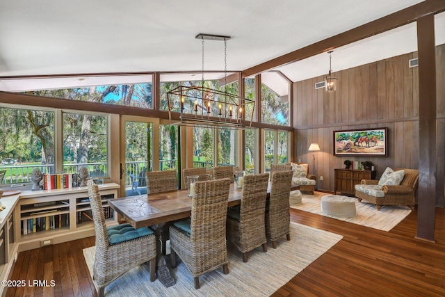 34 W Beach Lagoon Dr, Hilton Head Island, SC 29928 - dining space featuring a chandelier, wood walls, hardwood / wood-style floors, beam ceiling, and high vaulted ceiling
