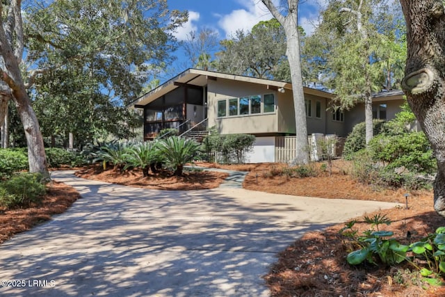 34 W Beach Lagoon Dr, Hilton Head Island, SC 29928 - view of front of property featuring stucco siding, driveway, and a sunroom