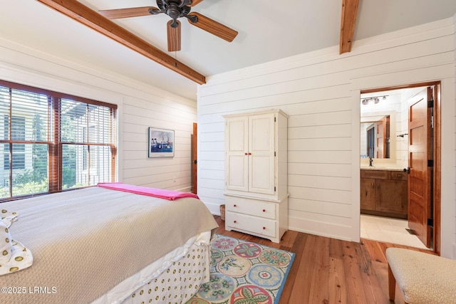 bedroom featuring ceiling fan, wooden walls, beam ceiling, and light hardwood / wood-style flooring