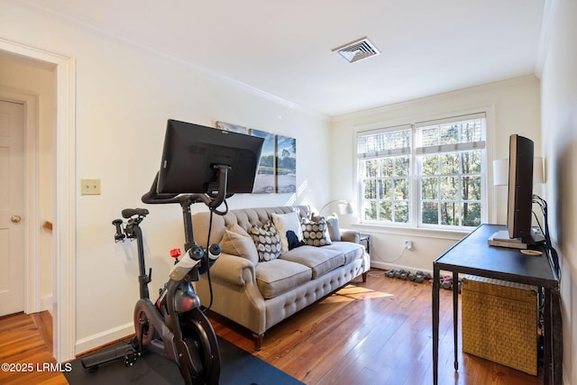 exercise room featuring ornamental molding and wood-type flooring