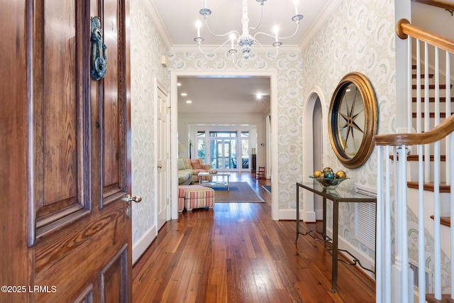 entryway featuring ornamental molding, dark hardwood / wood-style floors, and a chandelier