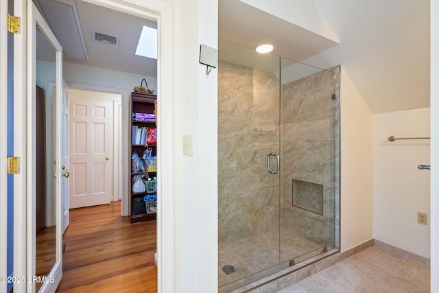 bathroom with hardwood / wood-style flooring and an enclosed shower