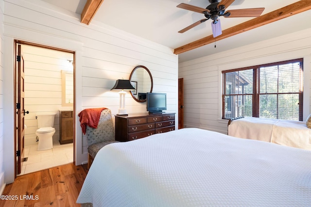 bedroom with hardwood / wood-style flooring, ceiling fan, beam ceiling, and wooden walls