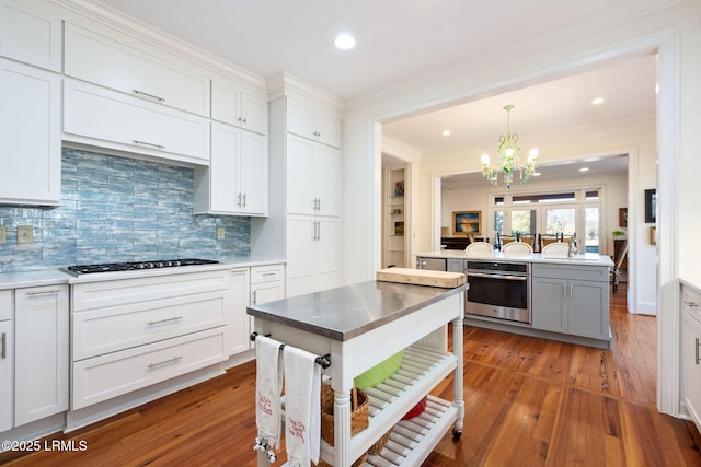 kitchen featuring white cabinetry, backsplash, stainless steel appliances, and a center island