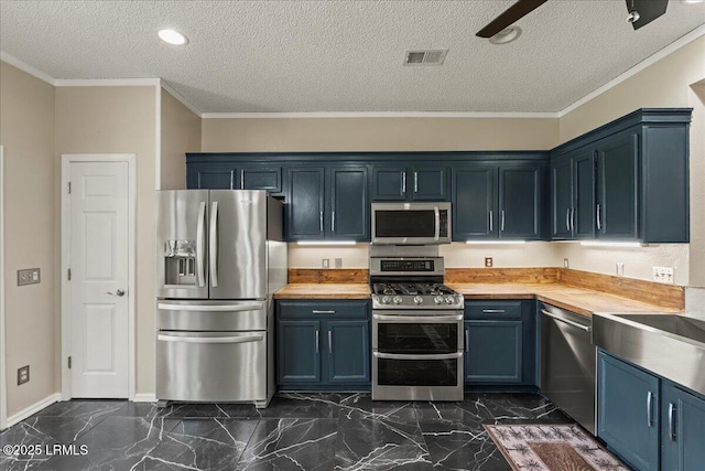 101 Redtail Dr, Bluffton, SC 29909 - kitchen featuring appliances with stainless steel finishes, wood counters, dark marble finish flooring, blue cabinetry, and a textured ceiling