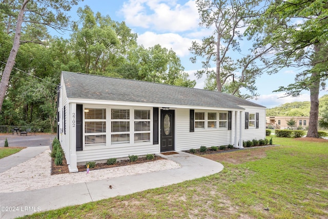 single story home featuring a front lawn