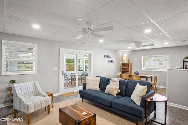 living room with ceiling fan, a healthy amount of sunlight, wood-type flooring, and a paneled ceiling