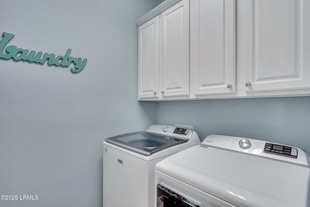 clothes washing area with cabinet space and washer and dryer