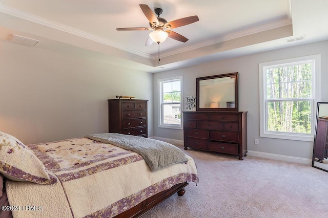 bedroom featuring ceiling fan, a tray ceiling, and multiple windows