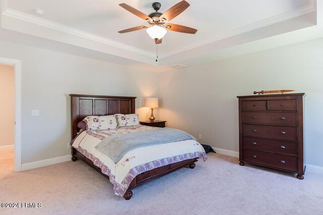 bedroom with crown molding, ceiling fan, a raised ceiling, and light colored carpet