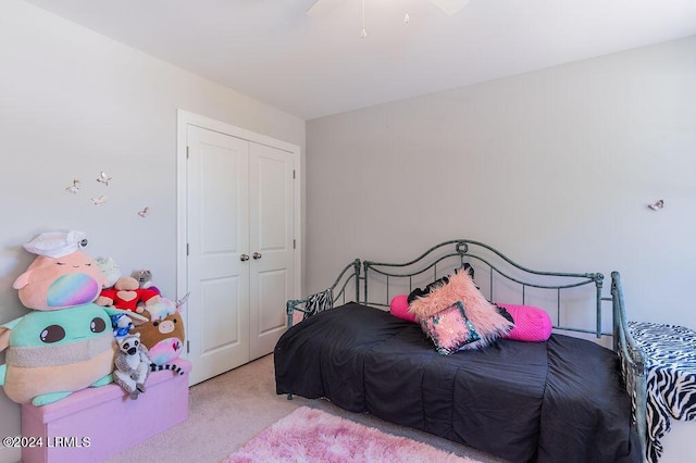 carpeted bedroom featuring ceiling fan and a closet