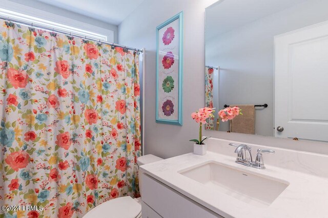 bathroom with a shower with curtain, vanity, and toilet