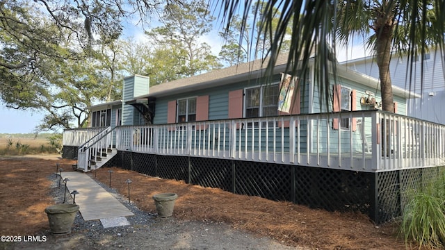 rear view of house featuring a wooden deck and a chimney