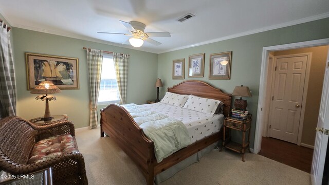 carpeted bedroom with visible vents, a ceiling fan, crown molding, and baseboards