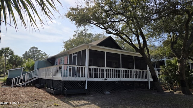 view of front of house with stairs and a sunroom