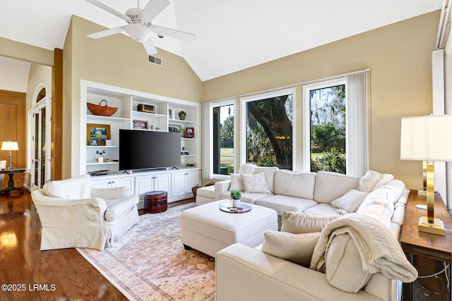 living room with high vaulted ceiling, wood finished floors, visible vents, a ceiling fan, and built in features