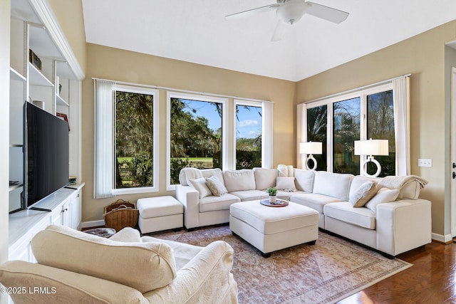 living room featuring dark wood-type flooring, vaulted ceiling, ceiling fan, and baseboards