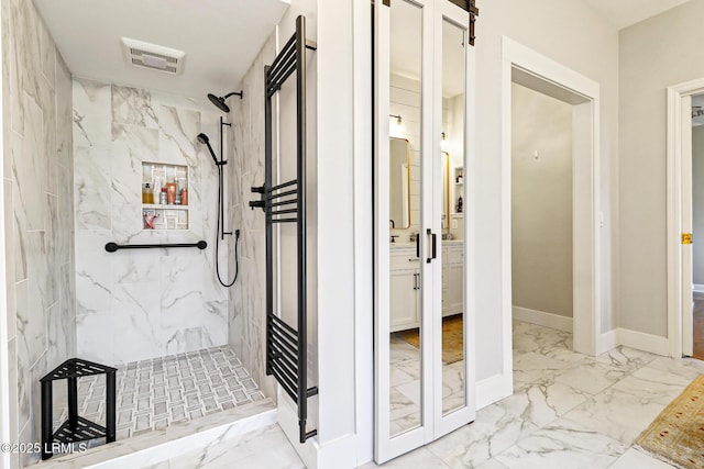 bathroom featuring marble finish floor, a marble finish shower, visible vents, and baseboards